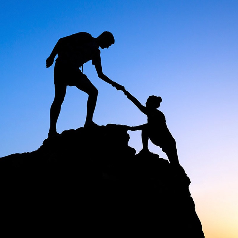 Image of someone helping someone up a cliff for SEO tips
