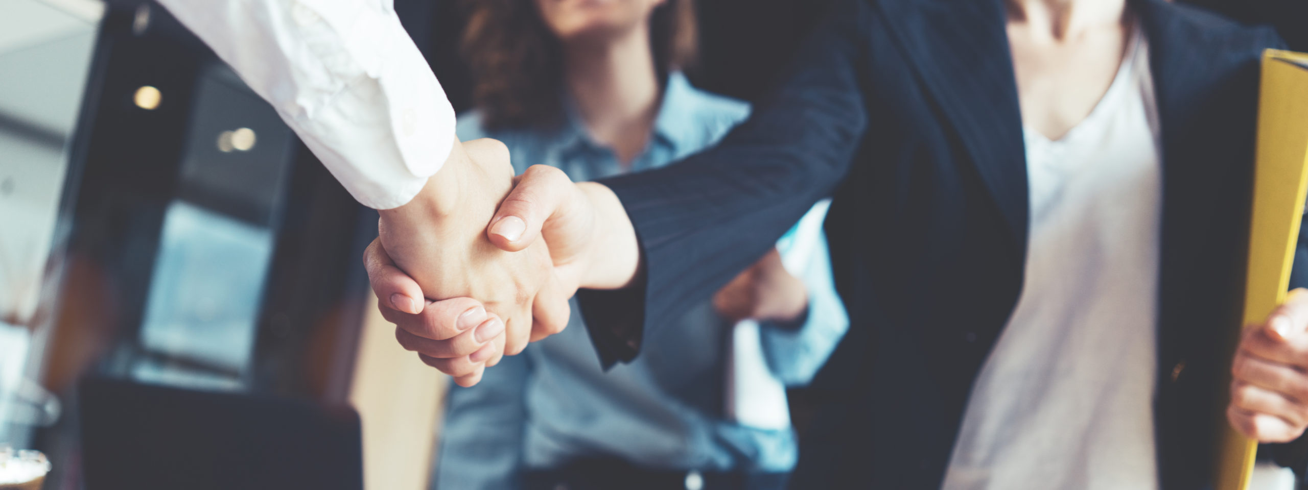 two formally dressed people shaking hands